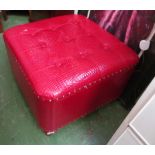 A red faux leather footstool