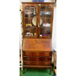 A walnut bureau bookcase on cabriole legs and three drawers