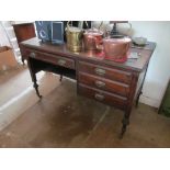 An Edwardian mahogany desk with four drawers on turned supports