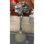 An Art Deco silver and gilt dancing figure standing on a crackle glass shade