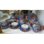 An oriental part teaset dragon design with blue ground, faces to base of cups (sa/f)