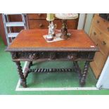 A Victorian carved oak two drawer writing table