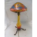 An Art Nouveau yellow and orange glass lamp with integral leaf and butterfly design stem with a
