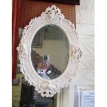 A white frame oval mirror with cherubs