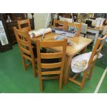 A light oak dining table with two end leaves and six chairs