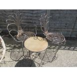 A pair of Peacock style metal garden chairs and an occasional table