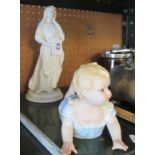 A painted metal figure of a lady and a piano baby