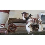 A cart horse ornament pulling a log trailer