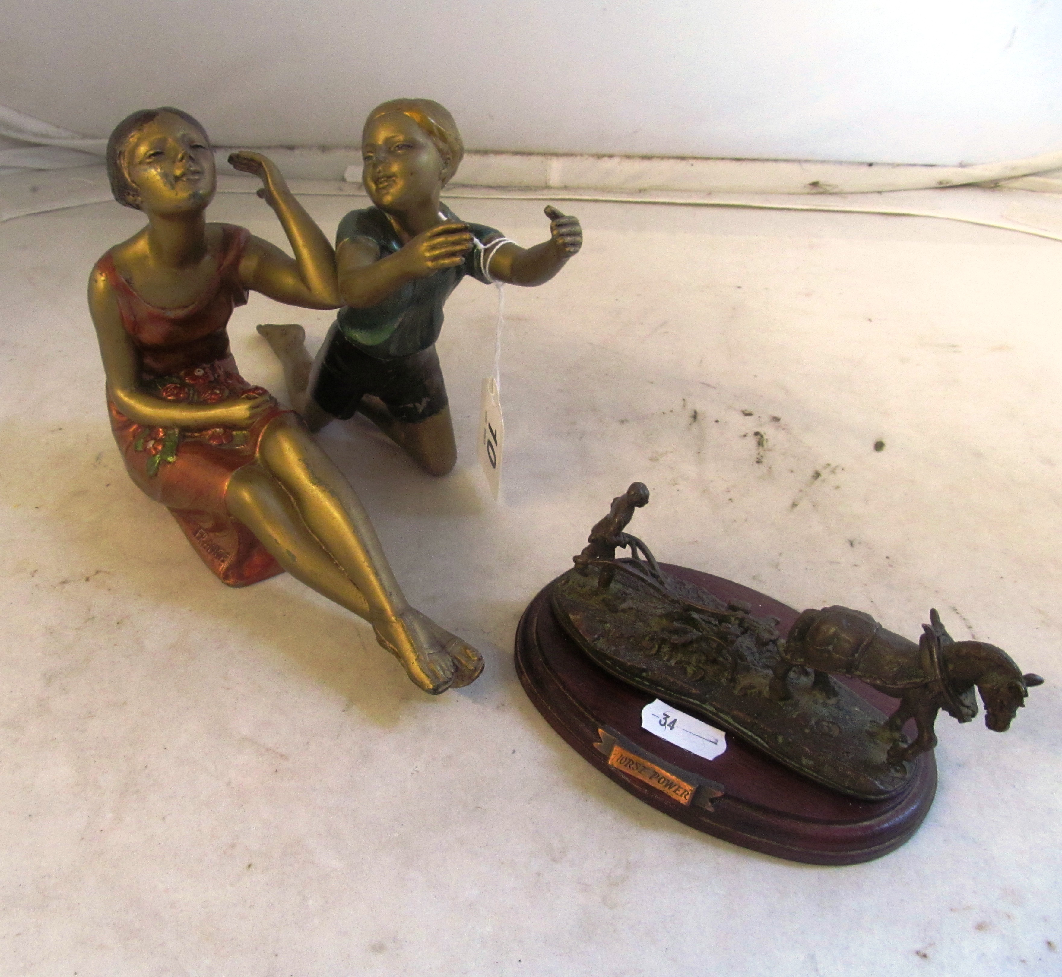 Two 1930s gilt and coloured figures (deficient of stands) and a metal figure Horse Power.