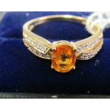 A 9k orange stone bow style ring.