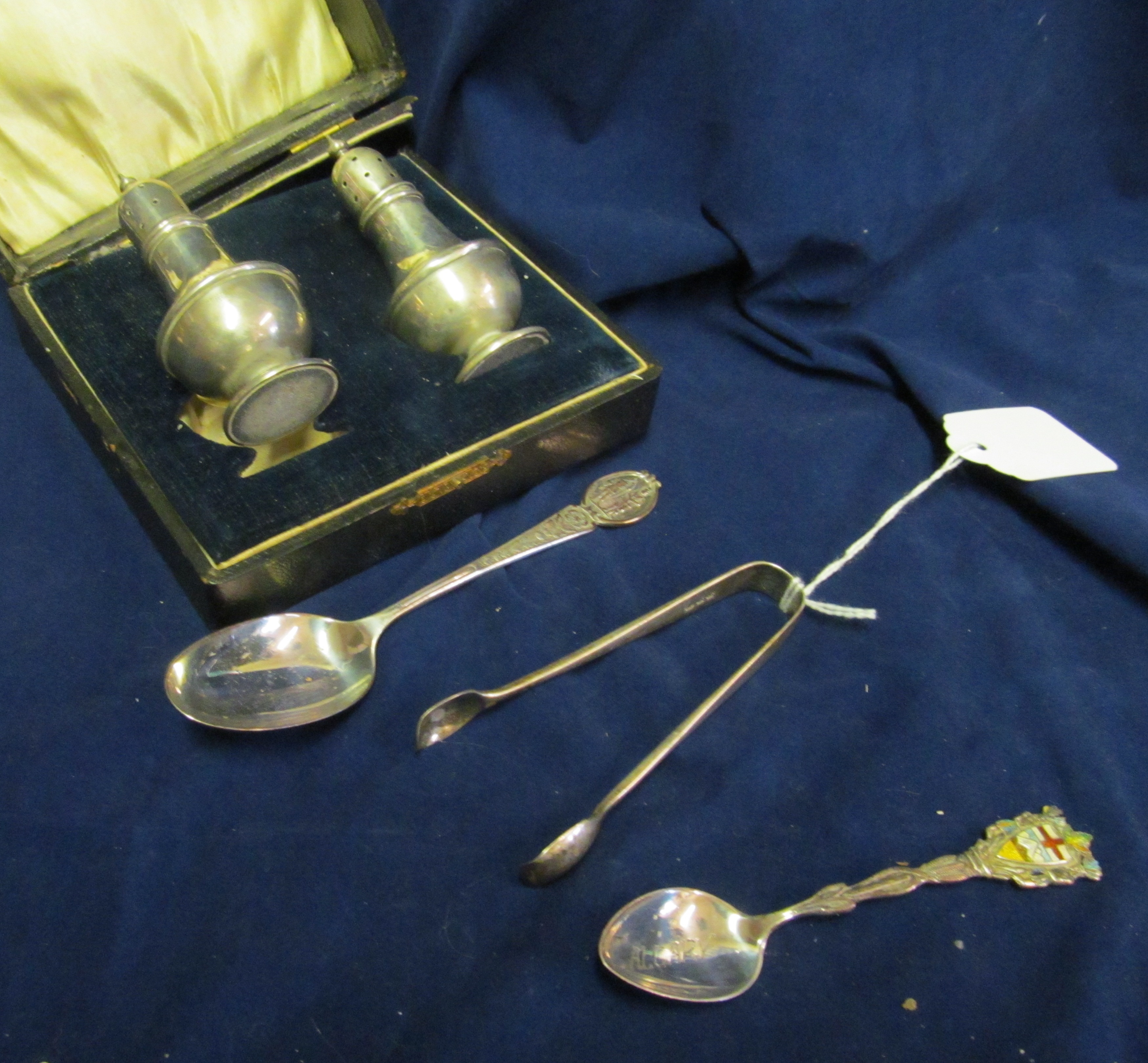 A pair of silver tongs, silver pepper and salt. and two spoons.