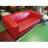 A contemporary design red leather three seater settee