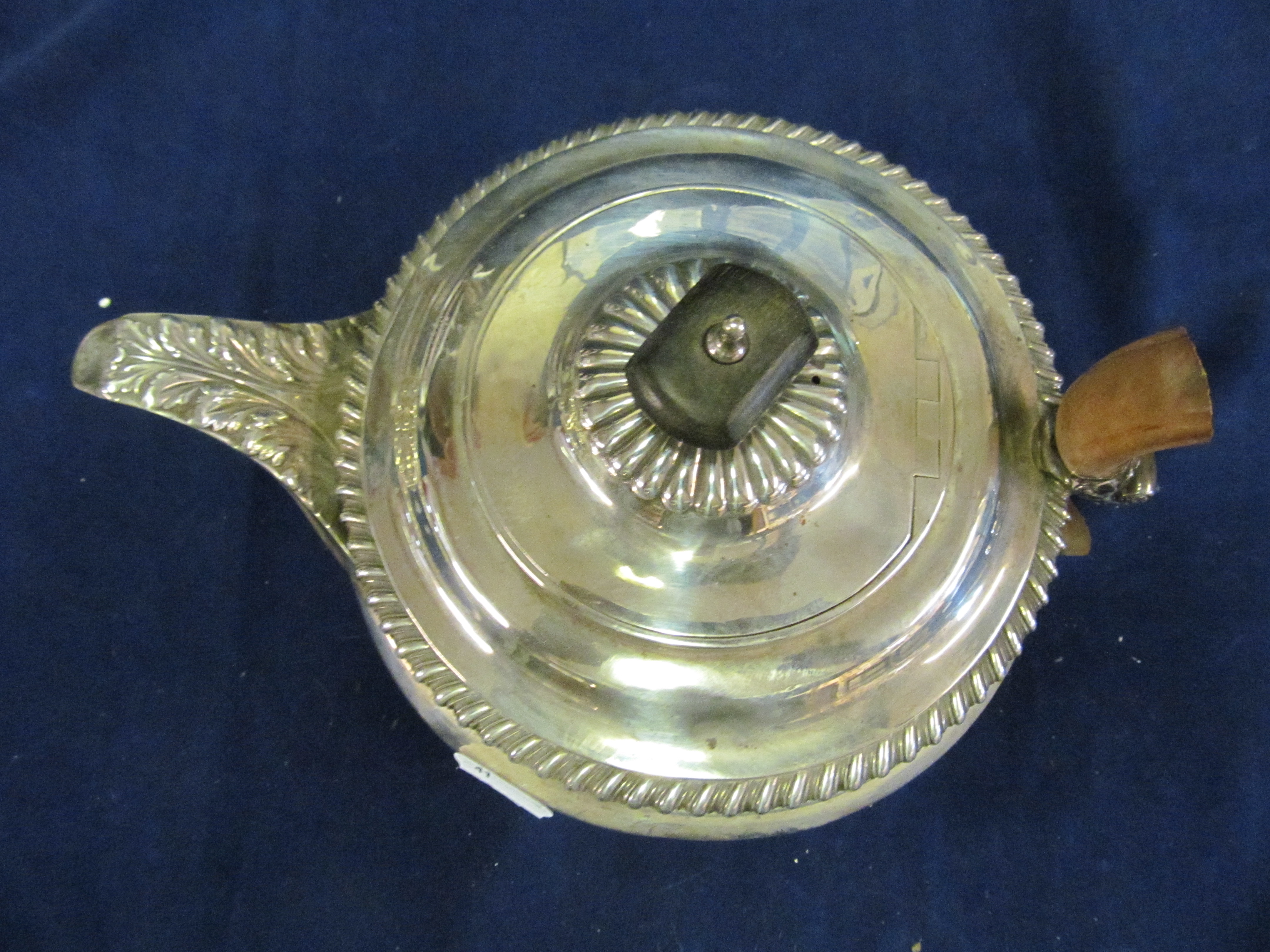 A silver teapot (broken handle)