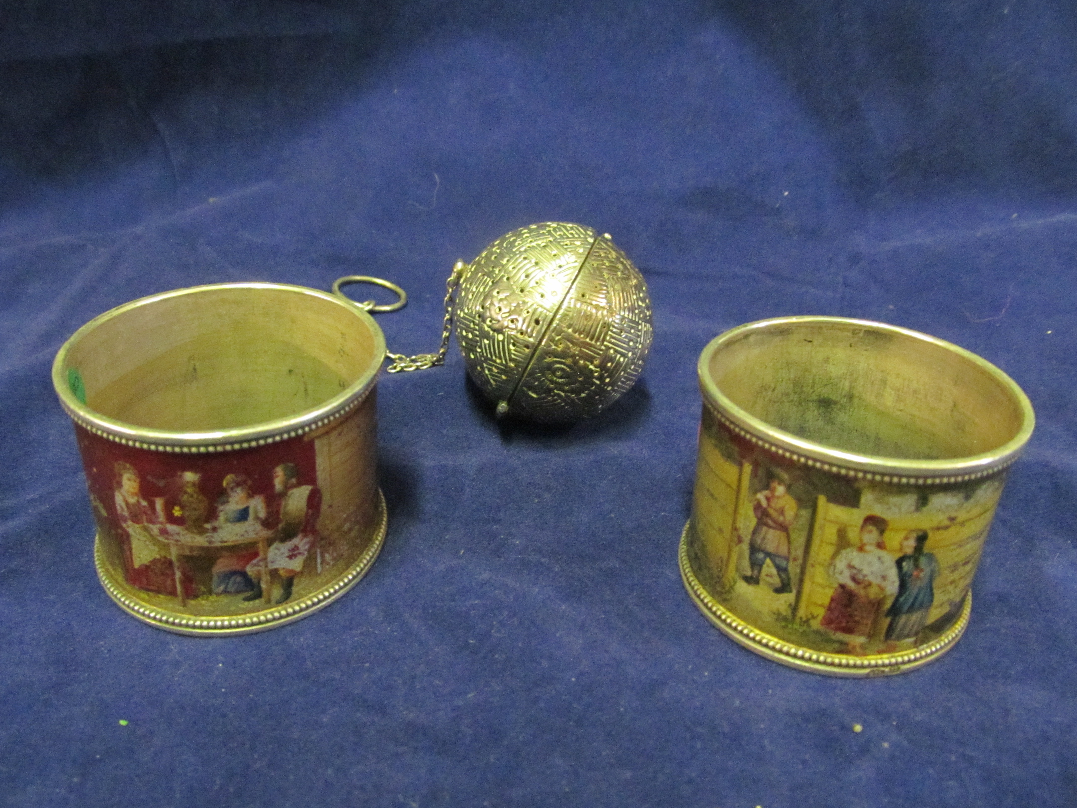 A pair Russian napkin rings and silver tea infuser