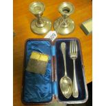 A pair of silver candlesticks, a silver engraved stamp case and a plated christening set (i.c)