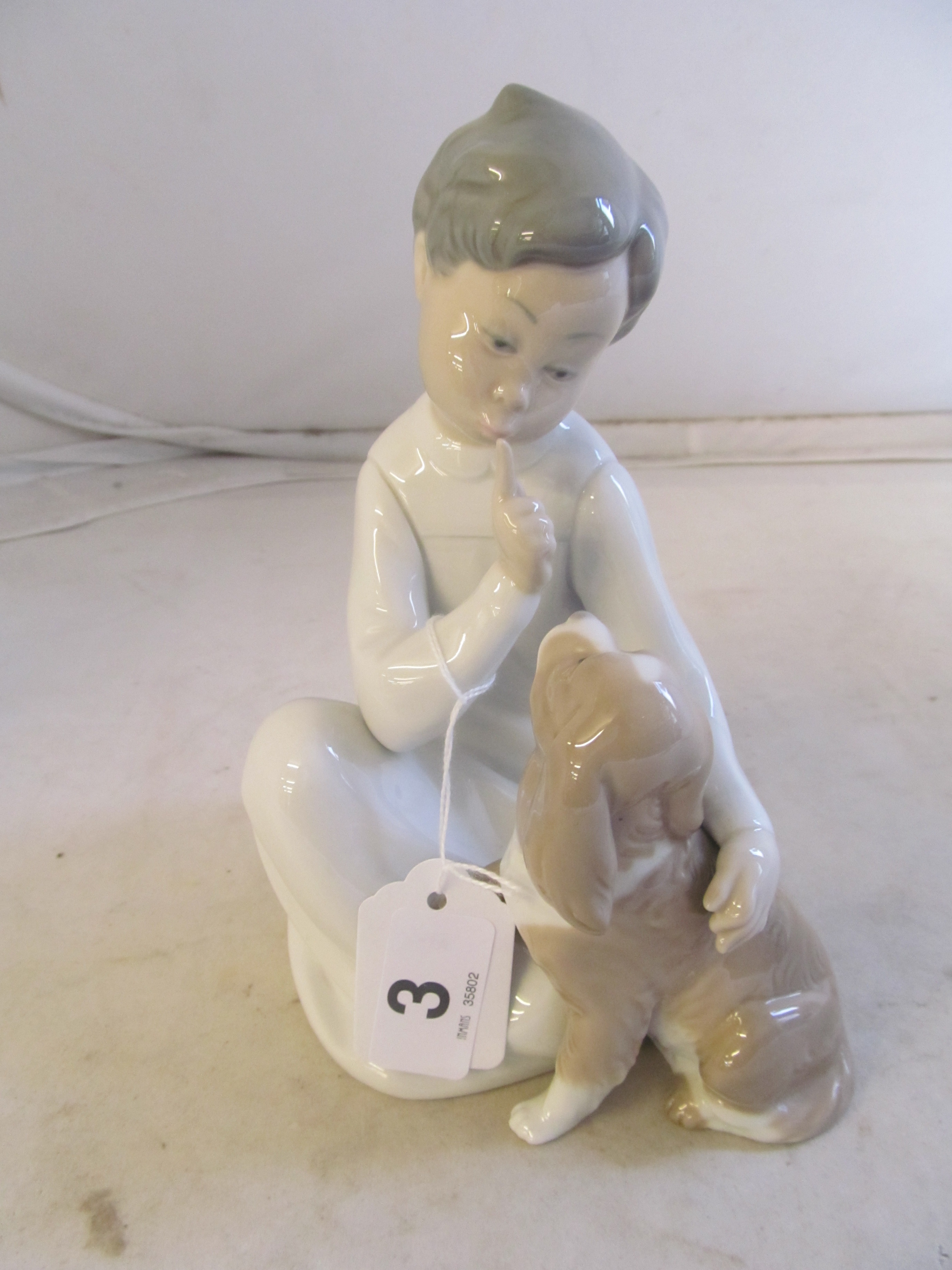 A Lladro boy and dog.