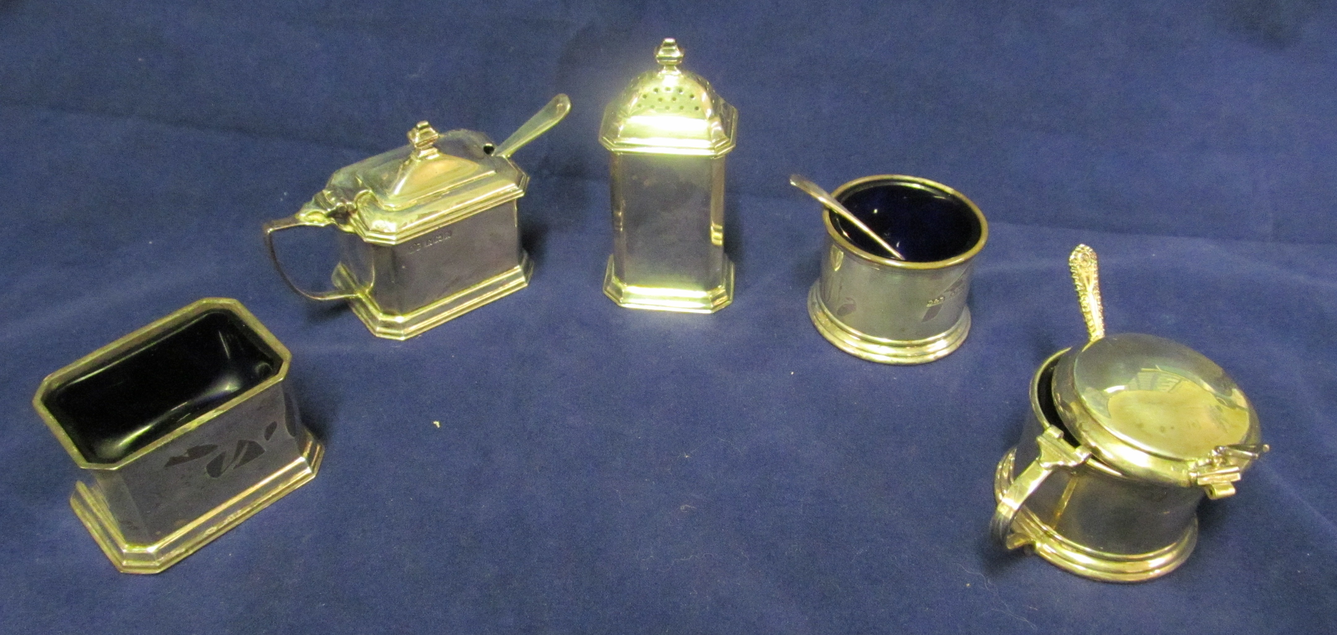 A silver three-piece condiment and two piece condiment