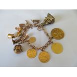 A charm bracelet with sovereign, half sovereign, George III gold coin and other charms