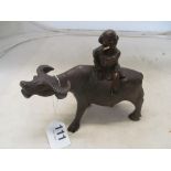 A treen figure riding on a bullock