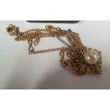 A gold and pearl pendant on chain