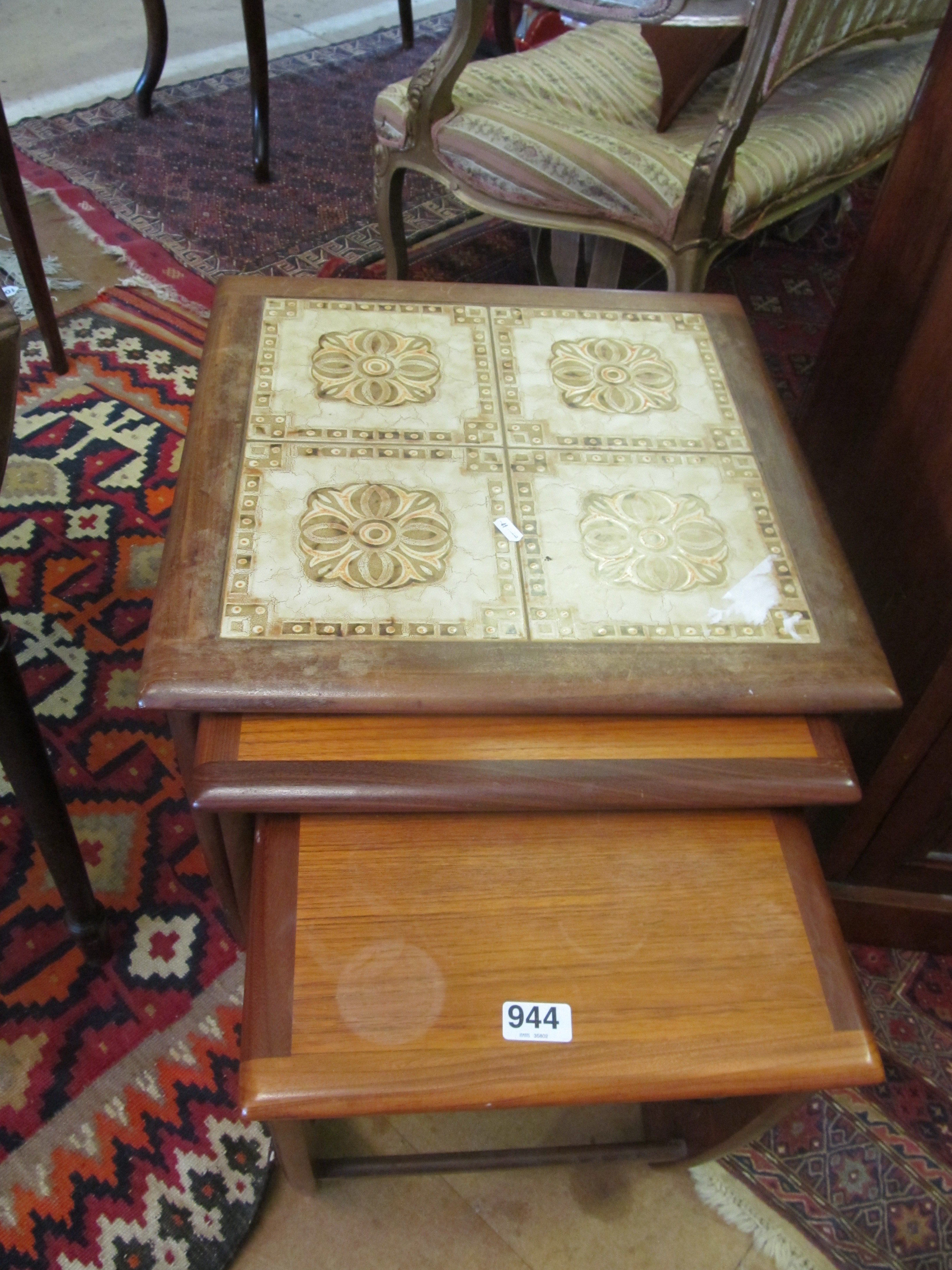 A Teak and tile top nest three tables