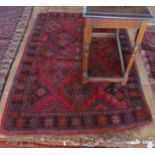 A Persian rug madder ground symmetrical design