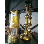 A pair of brass candlesticks, and a brass miner's lamp.