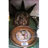 An oak plaque three horned face and a Victorian pot lid in oak frame 'I consent she replied'