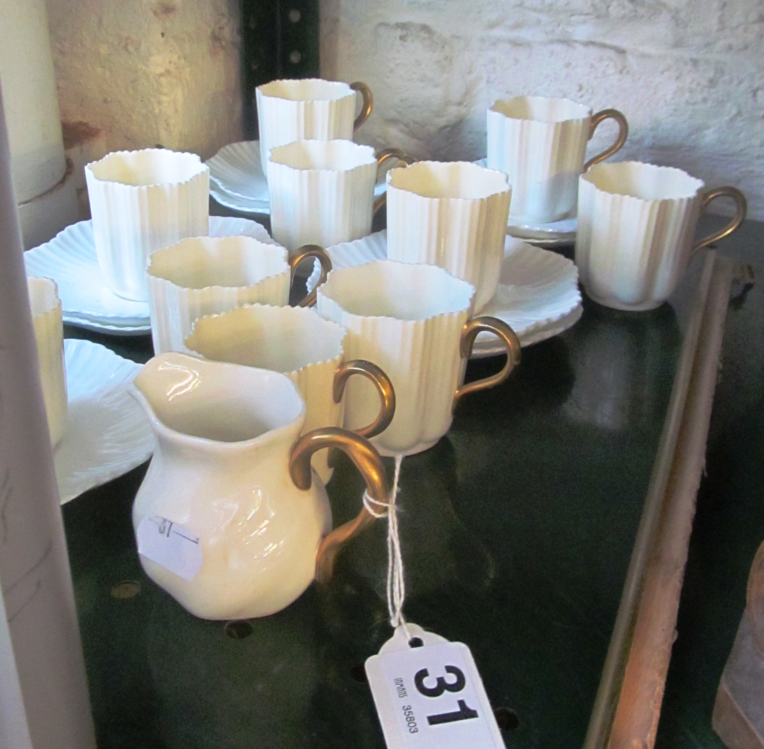 Ten Coalport cream and gilt coffee cups, nine saucers and a cream jug.