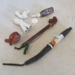 A 19th Century German porcelain pipe with scene of courting couple and other pipes