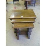 A nest of three oak occasional tables on turned supports