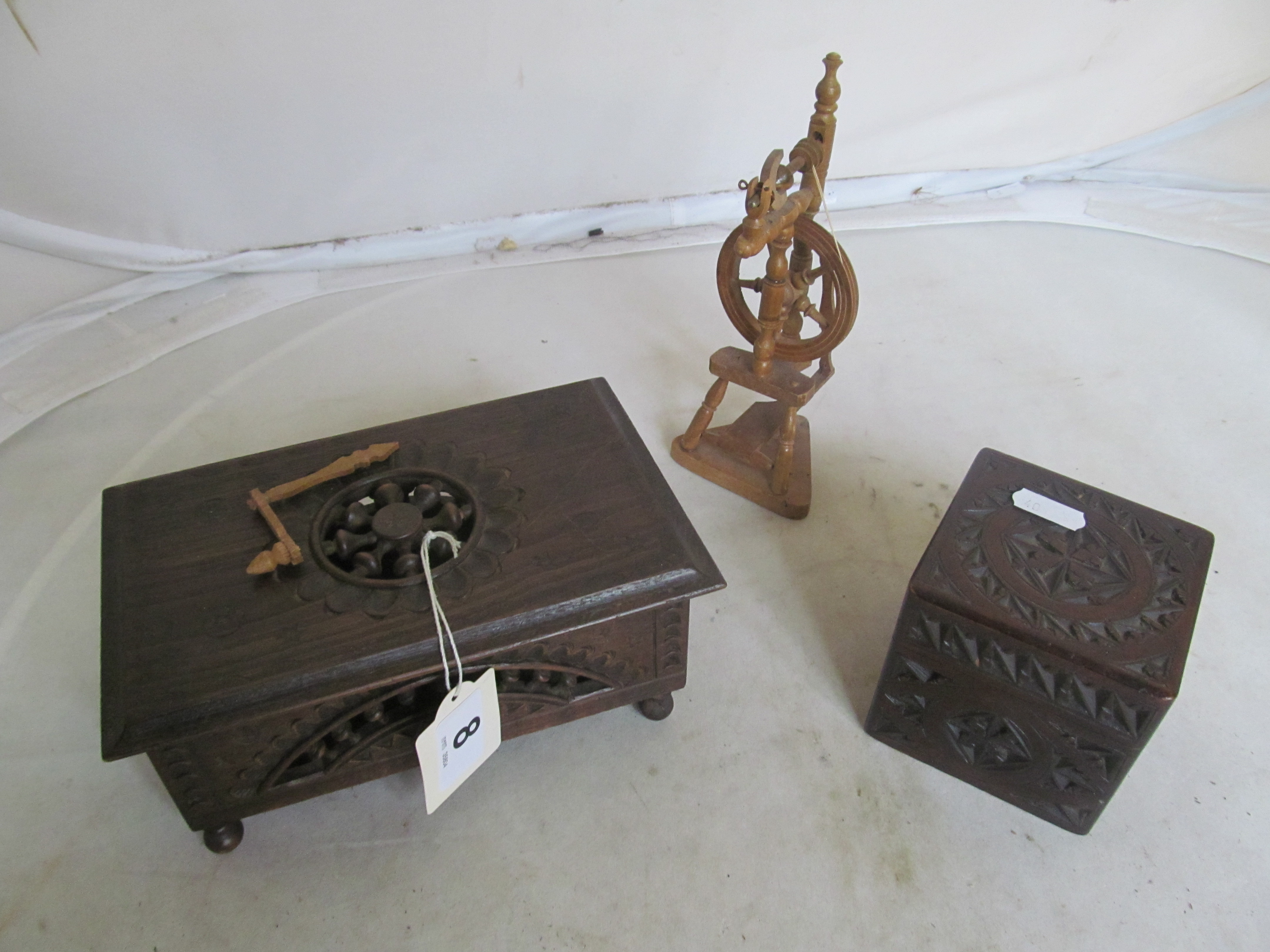 Two early 20th Century carved treen boxes and a miniature spinning wheel