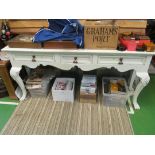 A cream painted long sideboard with three frieze drawers and shell capped cabriole supports