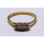 An 18ct yellow and white gold three stone illusion set diamond ring