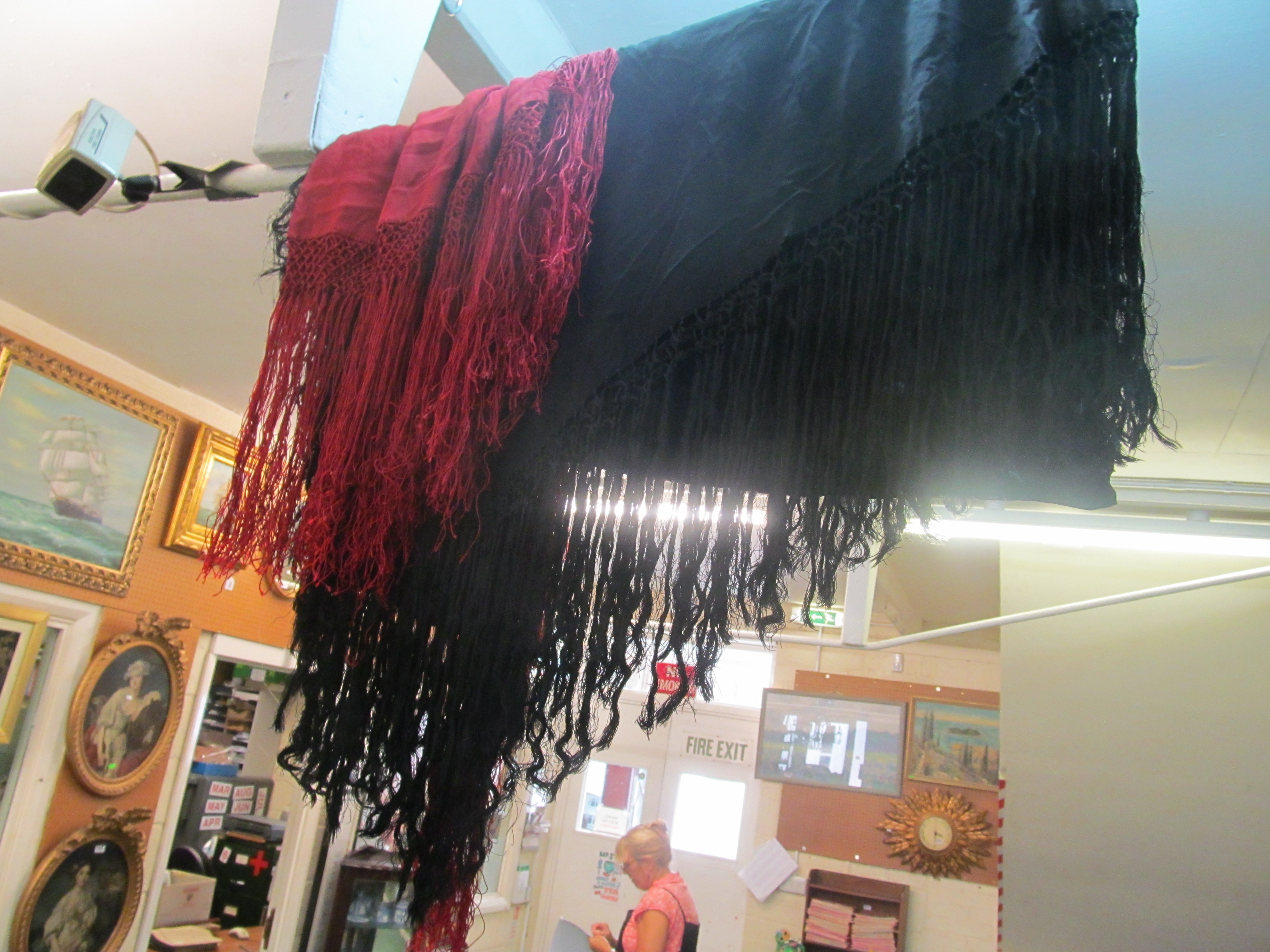 A black embroidered silk shawl with tassel edge and another red one
