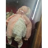 An Armand Marseilles baby doll with bisque head, open mouth revealing teeth and closing blue eyes