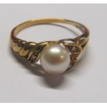 A 15ct gold single pearl ring surrounded by three brilliant cut diamonds
