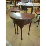 A small demi-lune mahogany tea table on tapered supports and pad feet