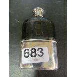 A small hip flask with silver corked screw top and leather and plated base