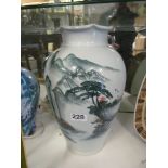 An oriental large vase, trees and mountain design signed on base.