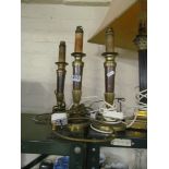 A set of three brass candlesticks as lamps