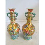 A pair of 19th Century Japanese vases with figures and dragons amongst foliage on gilt ground and