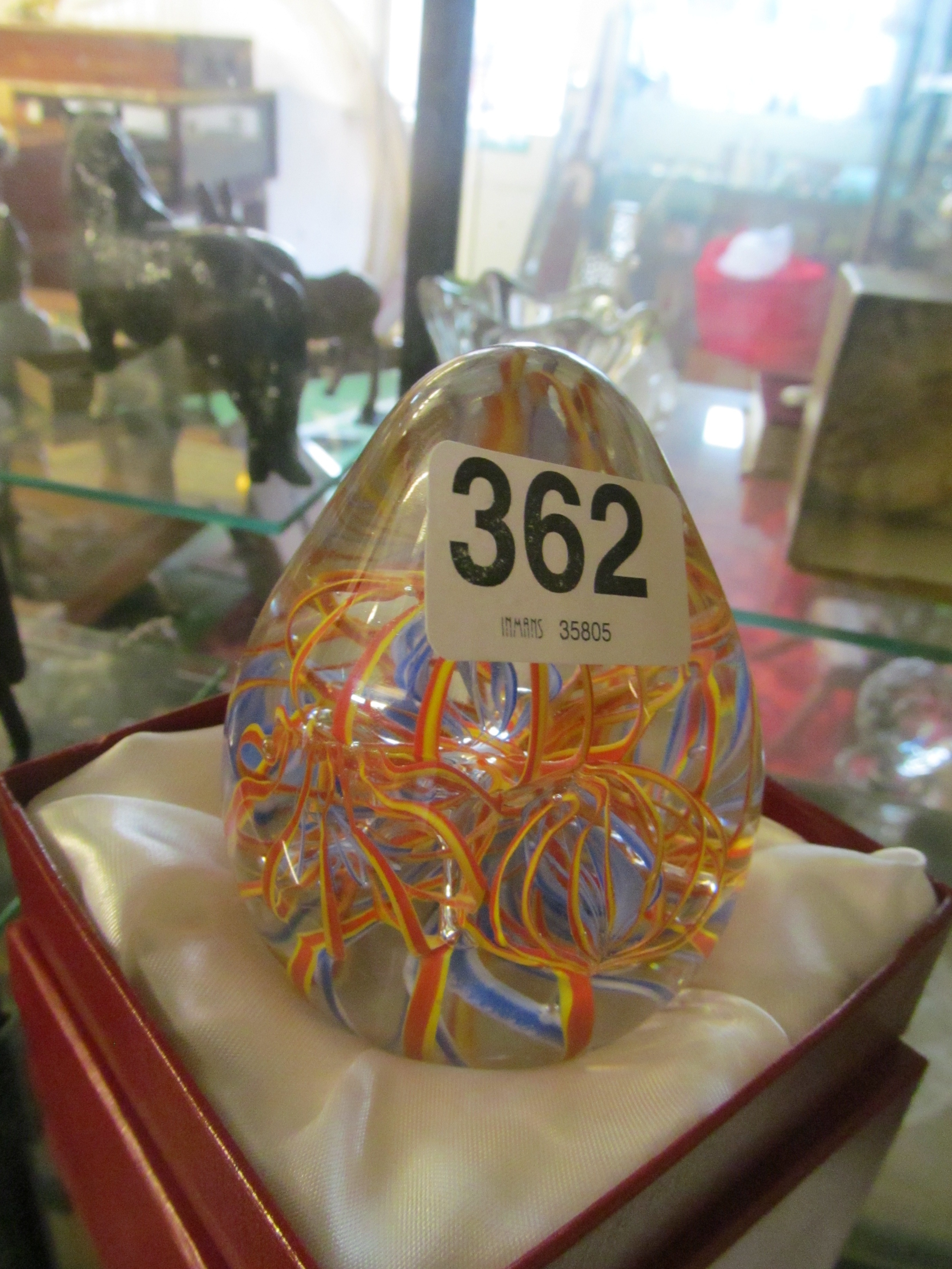 A paperweight with blue and yellow swirl design.