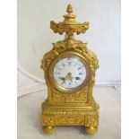 A 19th Century gilt bronze mantel clock with lid to ram's head urn, mask sides