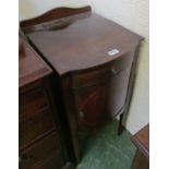 An Edwardian mahogany bow front bedside cupboard with frieze drawer, on square tapered legs