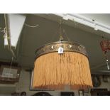 A circular metal chandelier with tasselled fringe