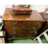 A George III mahogany chest of four graduated long drawers, fitted brass loop handles with pierced