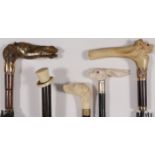 FOUR CARVED CANE/UMBRELLA HANDLES, C. 1900