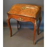 A 19th Century French Walnut And Gilt Metal Mounted Bombe Bureau Dame, the fall front enclosing a