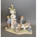 A Lladro Porcelain Large Group In The Form Of Children And Dogs Beside A Pillar, upon a shaped base,